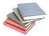 several books are stacked on top of each other on a white surface