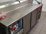 stainless steel counter top in a commercial kitchen with a refrigerator