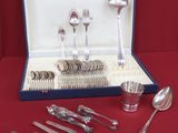 une boîte contenant des couverts et des cuillères posée sur une table rouge