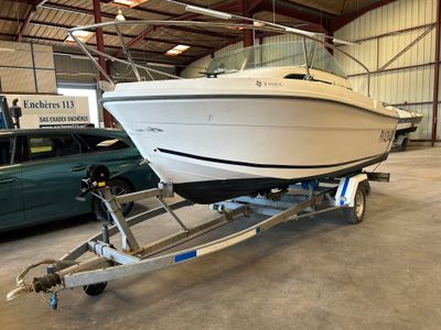 a white boat on a trailer in a garage