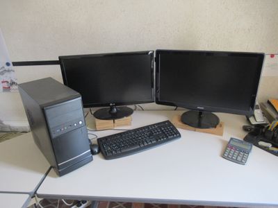 un bureau d'ordinateur avec deux écrans et un clavier