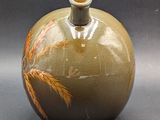 a small vase with a brown and orange design on it