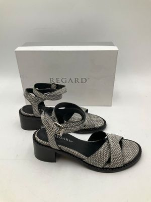 une paire de sandales noires et blanches posées sur une surface blanche