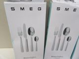 two boxes of silverware sitting next to each other on top of a table