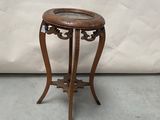 a small wooden table with a glass on top