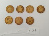 a group of five gold coins with a price tag on them