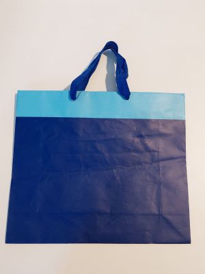 un sac de courses bleu et noir accroché à un mur