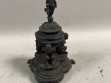 un bougeoir ancien en fonte surmonté d'une figurine