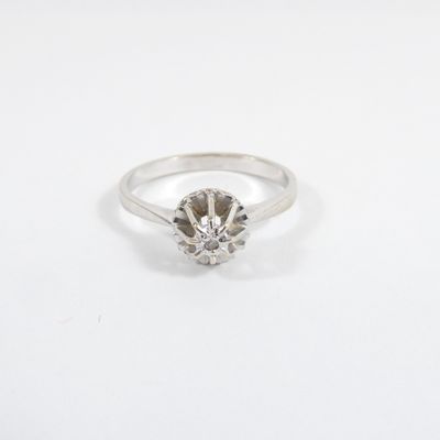 a close up of a diamond ring on a white surface