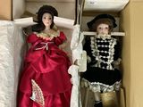Deux poupées dans une boîte : l'une porte une robe rouge et l'autre une robe noire et blanche.