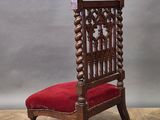 an old wooden chair with red velvet upholstered seat