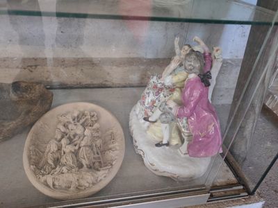 une vitrine contenant une statue de femme et un bol de nourriture