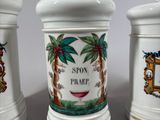 three white ceramic containers with pictures of palm trees and palm trees on them