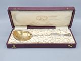 a gold spoon and a silver spoon in a purple case