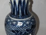 un vase bleu et blanc posé sur une surface blanche