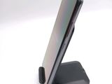 a cell phone sitting on a stand on a white surface