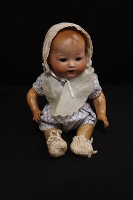 a small doll that is sitting on a black surface
