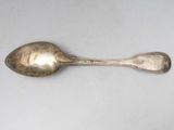 a silver spoon with a spoon handle on a white surface