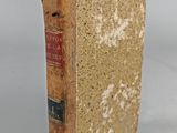 an old book sitting on top of a table next to a white wall