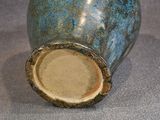 a blue vase sitting on a table with a brown lid