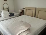 deux lits dans la chambre, recouverts de draps blancs