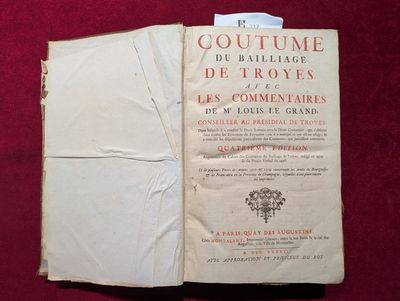 un livre ouvert posé sur un tissu rouge, d'où dépasse un bout de papier