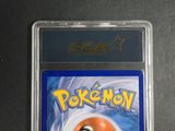 the pokemon card is in a plastic holder on a table