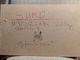a cardboard sign on a chair that says suro