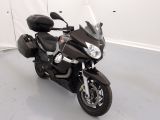une moto garée dans une pièce aux murs blancs