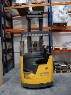 un chariot élévateur dans un entrepôt rempli de rayonnages et de cartons