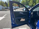 a blue car with its door open in a parking lot