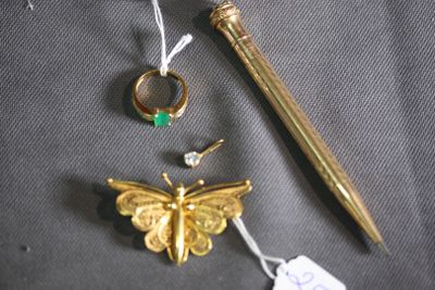 a gold pen, a ring, a butterfly, and a pen on a table