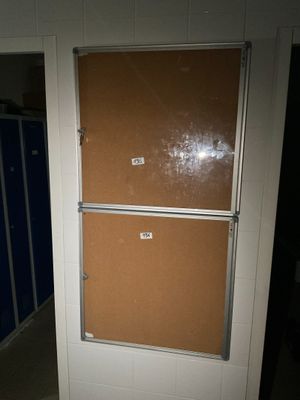 une porte sur laquelle est fixé un tableau en liège, dans une salle de bains
