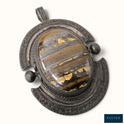 une photo d'une photo d'un pendentif serti d'une pierre