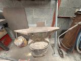 an old iron an anvil on the floor of a garage