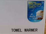 a sign on the side of a refrigerator that says towel warmer