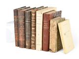 plusieurs vieux livres sont empilés sur une surface blanche
