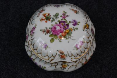a white box with flowers on it on a black surface