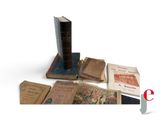 several old books sitting on top of each other on a white surface