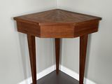 une table d'angle avec un plateau en bois, placée dans un coin de la pièce