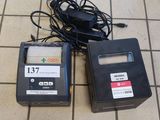 deux appareils électroniques posés par terre l'un à côté de l'autre