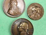 three different types of bronze coins on a green surface
