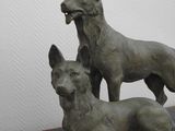 two statues of dogs sitting on top of a table