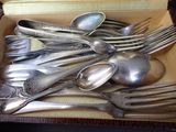 a lot of silver spoons and spoons in a box