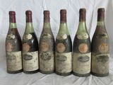 six bouteilles de vin sont alignées sur une table