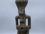 une vieille statue en bois représentant un homme tenant un bébé dans ses bras