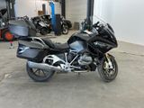 a black motorcycle parked in a garage with other motorcycles in the background