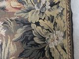 a close up of a tapestry with a bird on it