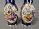 two vases with flowers painted on them sitting on a table