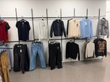 a lot of clothes hanging on a rack in a store